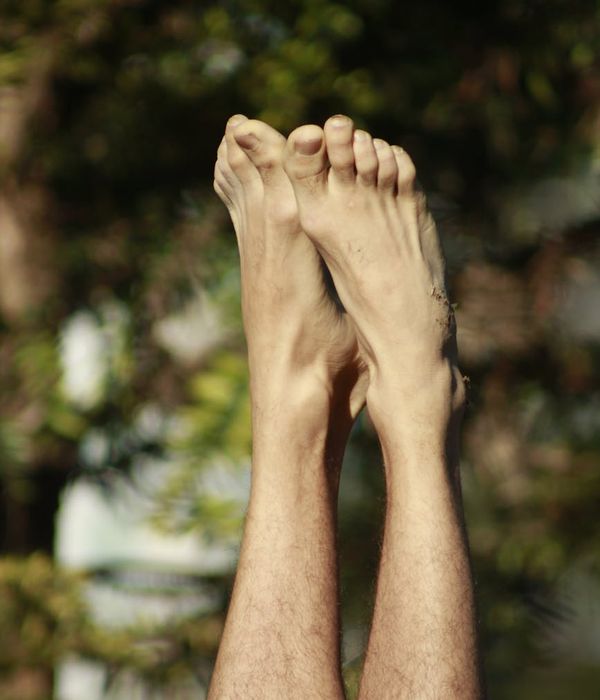 Man stretching outdoors with a serene natural background.